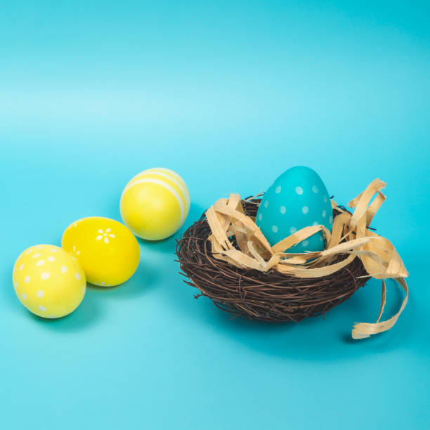 istock Colorful Easter eggs in the nest on blue background. Easter holiday concept, flat lay, top view. Copy space 1471188054