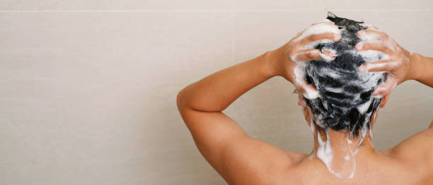 A man is washing his hair with shampoo stock photo