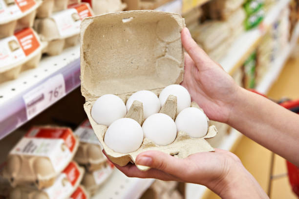 istock Hands with packages of white eggs in store 1471198304