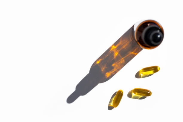 istock Fish oil capsules and bottle with drop shadow on white background. Top view, place for text. 1471200392