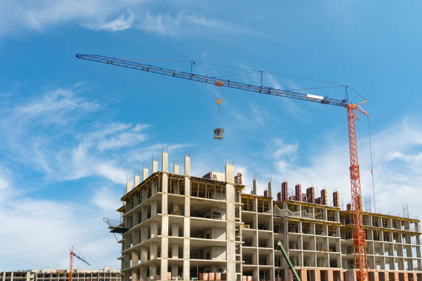 istock Unfinished cement building at a construction site. Large construction crane. 1471205133