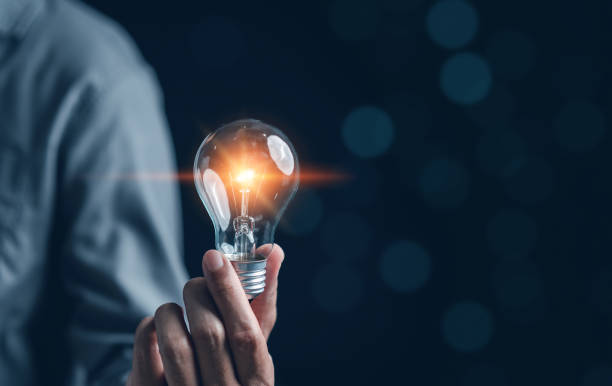 istock Hand man holding illuminated lightbulb, idea, innovation and inspiration with glowing virtual brain, smart intelligent creativity with bulbs, Motivation and innovation concept. 1471205362