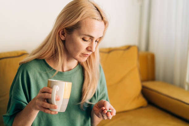 istock A woman takes a pain pill. 1471205965