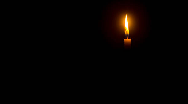 istock A single burning candle flame or light glowing on an orange cand 1471206316