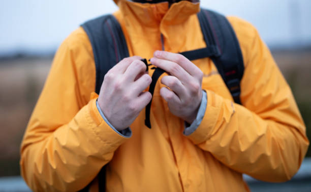istock Hiking Man with waterproof raincoat and backpack 1471208985