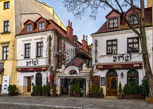 Krakow, Poland - November 12, 2022: Cafe on the sidewalk in the old Jewish quarter of Kazimierz in Krakow, Poland. Traditional Polish and Jewish cuisine. Tourist walk along the historical street