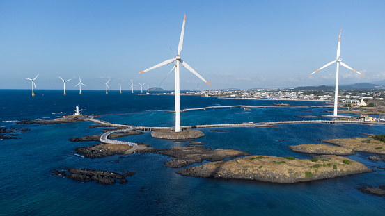 Drone shot of wind turbines located near Sinchang Windmill Coastal Road, Sinchang-ri, Jeju Island, South Korea.