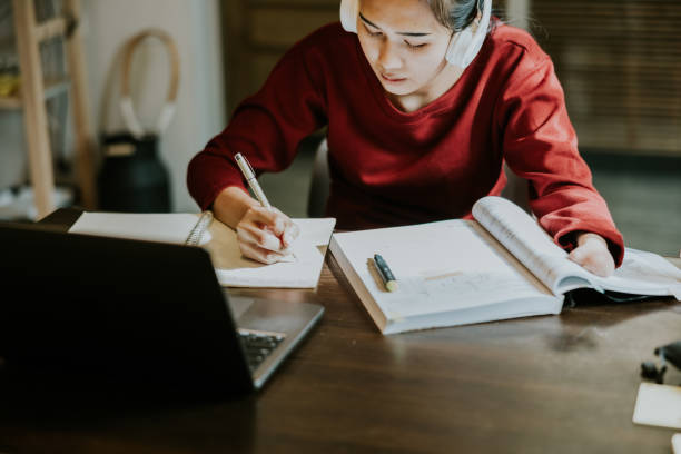 Young asian woman with hand disability is studying on online class.