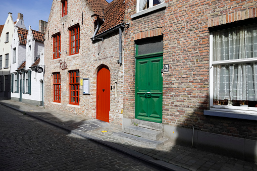 Bruges, Belgium - September 12, 2022: Narrow cobbled streets often with small houses along them are located in the old part of the city, well known for its preserved old architecture