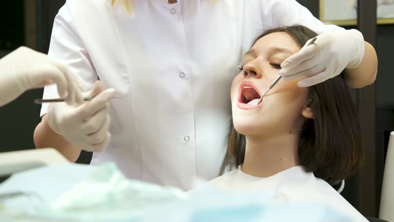 The Dentist and her assistant is working on patient in dental clinic