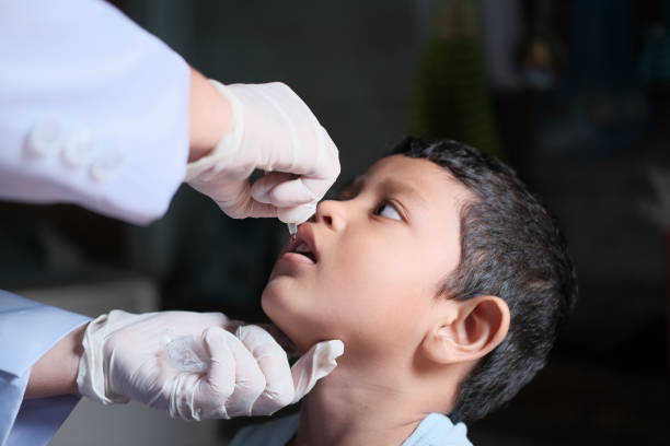 administrar vacina oral contra o vírus da poliomielite a crianças pequenas - administering - fotografias e filmes do acervo