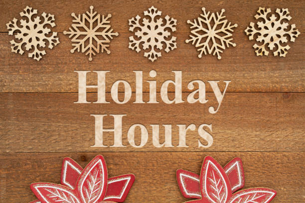 Holidays Hours message with snowflakes on weathered wood