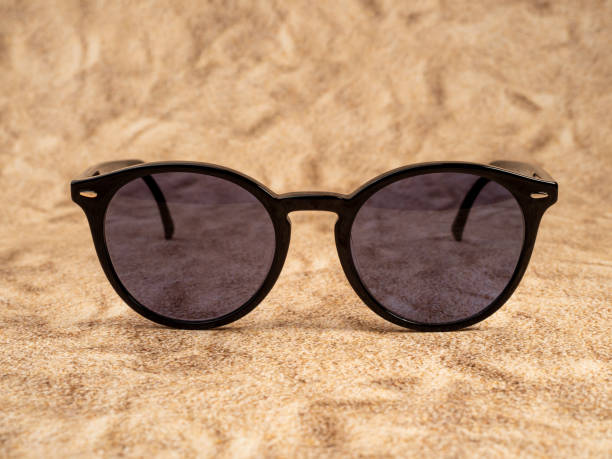 istock Stylish sunglasses. Sunglasses in a dark frame on a sandy background. 1471230445