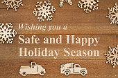 Safe and Happy Holiday Season message with wood snowflakes and retro trucks