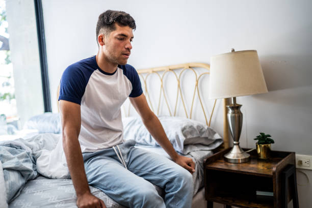 istock Young man sitting while waking up in the bedroom at home 1471232622