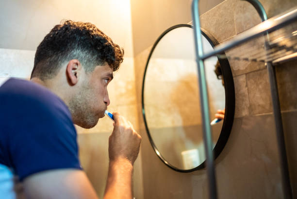 istock Young man brushing his teeth at the bathroom 1471232643