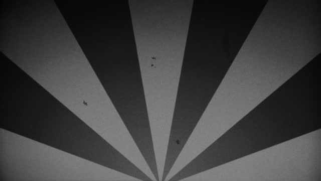 Vintage style, rotating black and white sunburst circle motion background. Retro animation with rays or stripes. Old look effects included; scratches, noise, dust, dirt, washed out. seamless loop.