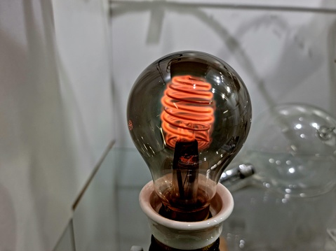 Vintage electric light bulb with a glowing wire.
