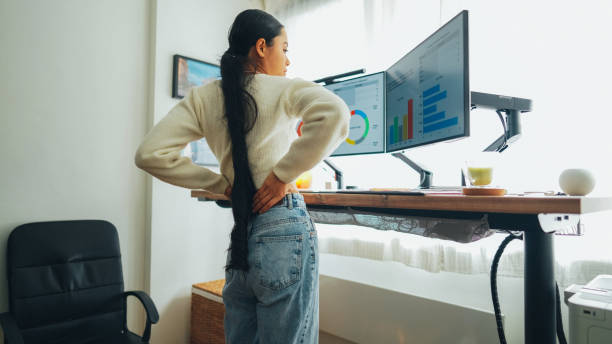 istock Woman with back pain working at standing desk home office 1471236788