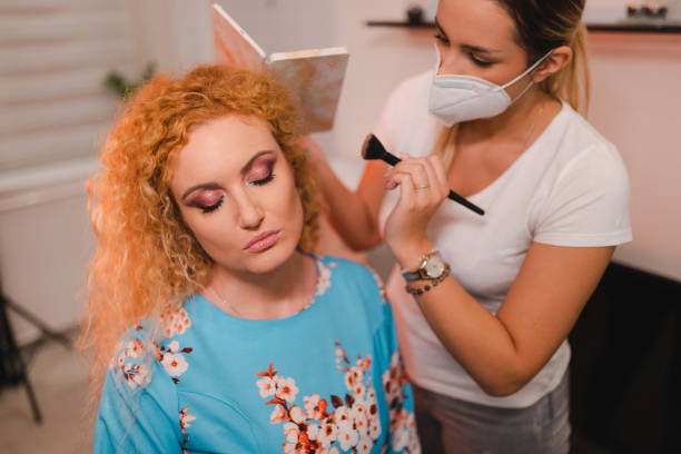 istock Beautiful blonde with curly hair getting her makeup done 1471239947