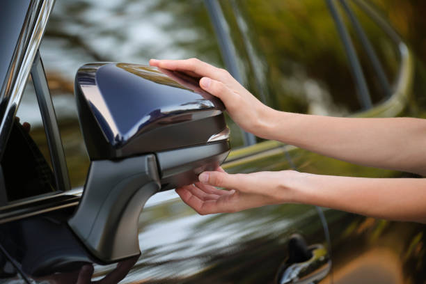 istock Driver hands adjusting side view mirror of a car 1471244749