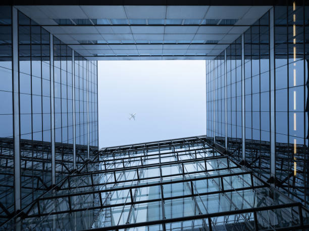 istock Modern construction with an airplane in the sky 1471245767