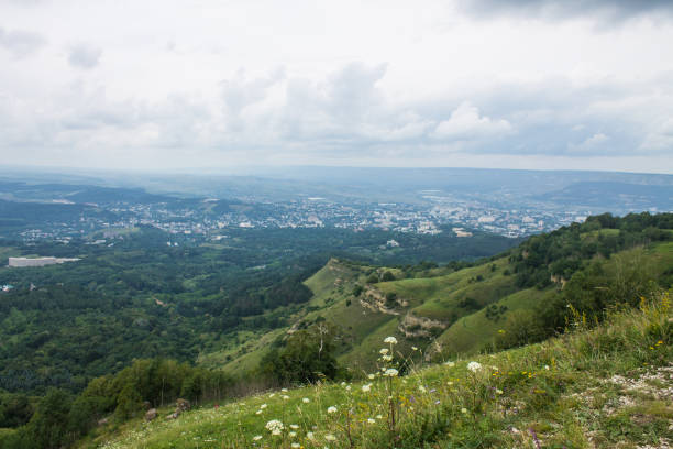 Beautiful hilly landscape - small saddle mountain with green grass and trees on a cloudy summer day and space to copy in Kislovodsk Stavropol region
