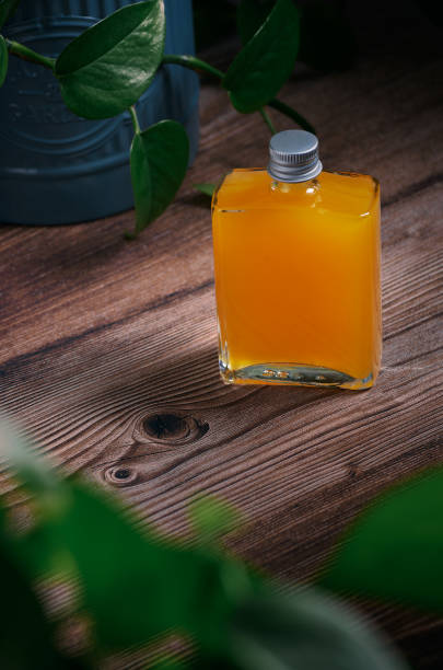 glass jar with orange prepared cocktail on a wooden table and plants around glass jar with orange prepared cocktail on a wooden table and plants around, no people sketch restaurant stock pictures, royalty-free photos & images