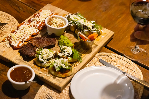 Mexican food platter with enchiladas, sopes, cecina and taquitos