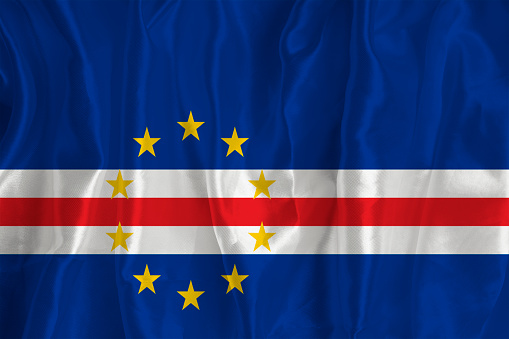 Flag of Cape Verde on a silk background is a great national symbol. Fabric texture The official state symbol of the country.