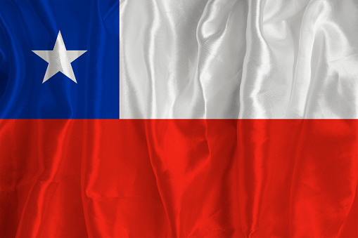 The flag of Chile on a silk background is a great national symbol. Fabric texture The official state symbol of the country..