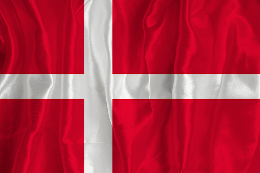 The Danmark flag on a silk background is a great national symbol. Fabric texture The official state symbol of the country.