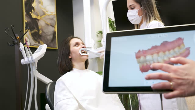 Doctor scans the patient's teeth in the clinic