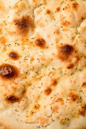 Close-up top view on round lavash with seasonings. Traditional tasty baked pita bread flat lay. Pizza base.