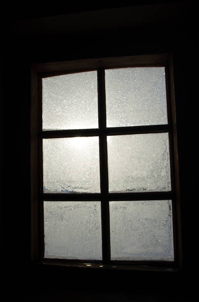istock lighted window with glass covered with frost from six segments on a dark background 1471267741