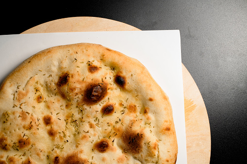 Round lavash - traditional tasty baked pita bread flat lay top view. Pizza base. Cropped photo