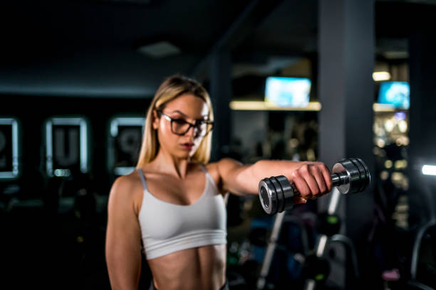istock Woman practicing with dumbbells in the gym 1471269556