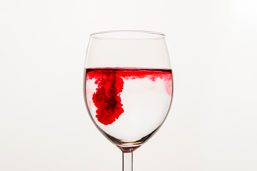 red swirling, liquid, transparent, glass cup