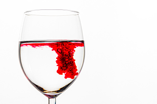 red swirling, liquid, transparent, glass cup