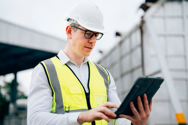 istock Male engineer using tablet while wearing equipment safety vest 1471278364