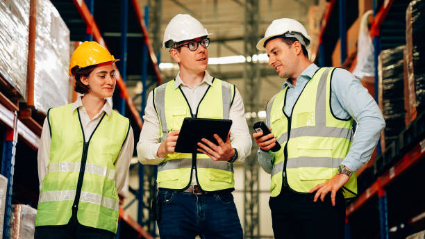 istock Professional warehouse workers with safety vest talking and discussing plan 1471279916