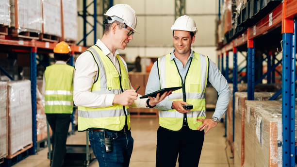 istock Two warehouse workers with safety helmet working at factory 1471280072