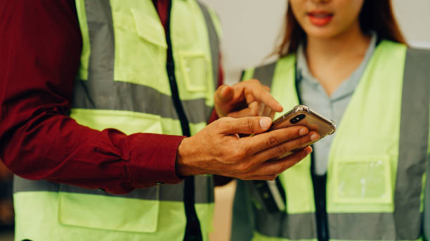 istock Two warehouse workers with safety helmet working together at factory 1471280936