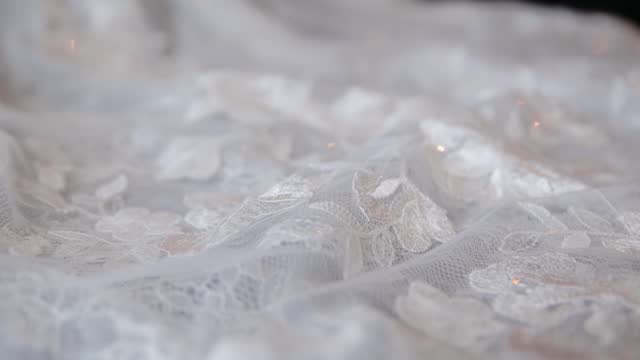 Close up macro shot view of wedding dress laces. Slow reverse movement with the camera using steadicam stabilizer
