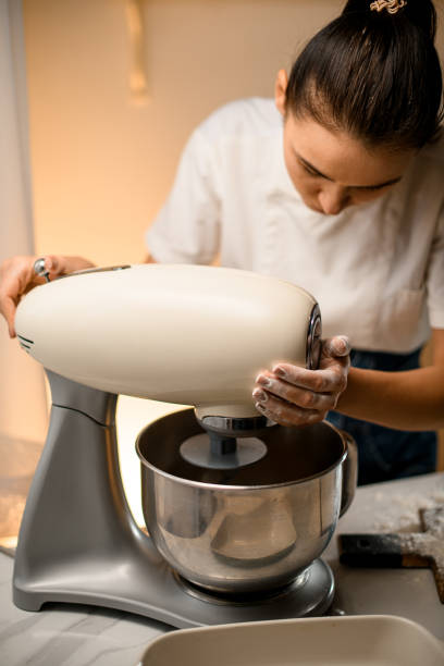 istock Woman prepares dough using modern electric kitchen stand mixer. 1471293838