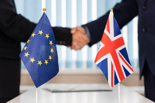 Political flags of European Union and United Kingdom on table. concept of negotiations, collaboration and cooperation of countries. agreement between governments. Political flags of European Union and United Kingdom on table. concept of negotiations, collaboration and cooperation of countries. agreement between governments diplomacy stock pictures, royalty-free photos & images