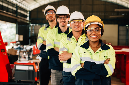 Group of confident engineers workers smiling standing at manufacturing factory