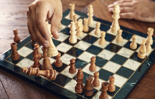 Close-up shot of person making checkmate in chess game.