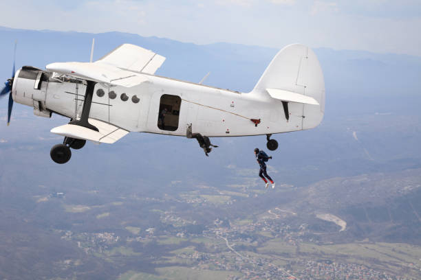 istock Parachutists jump from a vintage biplane 1471313090