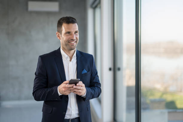 istock Happy businessman checking e-mails on phone in the office. 1471318875